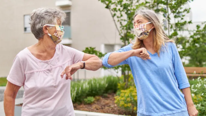 seniors wearing masks and saying hello through an elbow tap